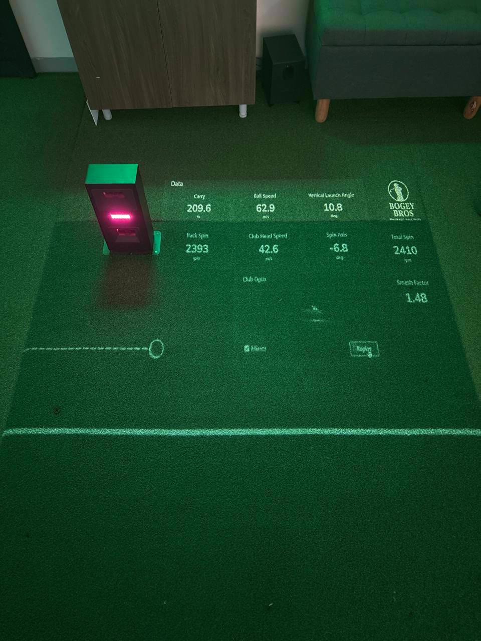Screen golf shot data projected onto the turf in the Bogey Bros bay in Singapore